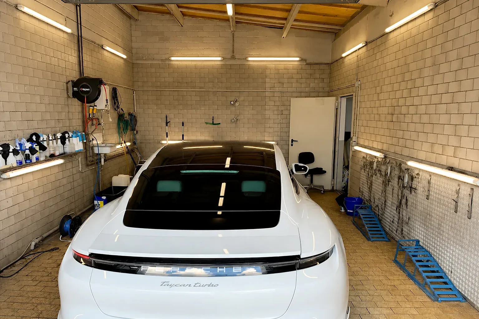 Weißer Porsche Taycan Turbo in der Aufbereitungshalle